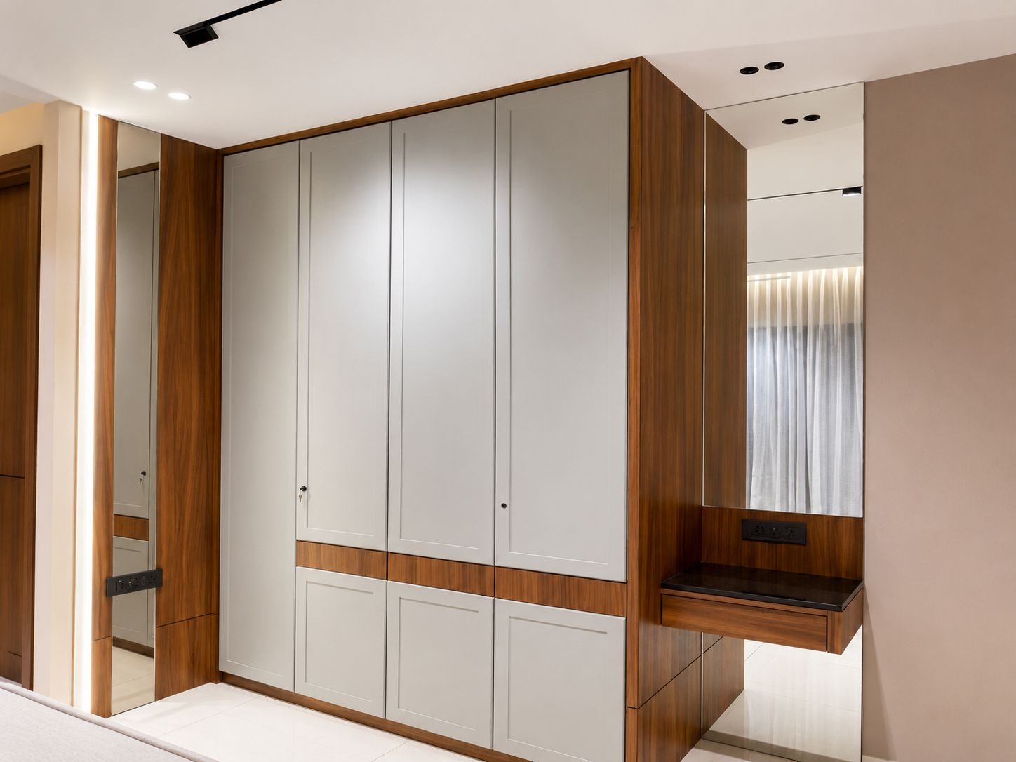 Dressing area with a mirrored wardrobe and floating console